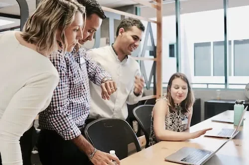 people huddling around computer