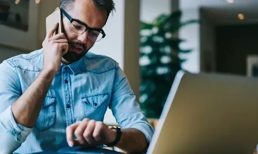 Man on Phone While Looking at Watch