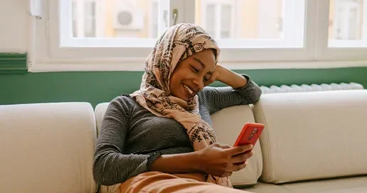 A woman sat down, smiling at her phone